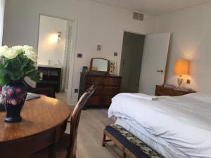a bedroom with a bed and a table with a vase of flowers at Private luxury retreat in Sible Hedingham