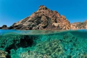 a rocky island in the ocean with a clear water at Borgo degli Ulivi in Porto Ercole