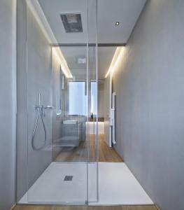 bagno con doccia e porta in vetro di Luxury Suites Collection - Frontemare Viale Milano 33 a Riccione