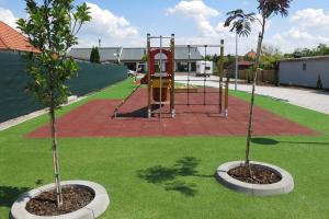 dos árboles en un parque con parque infantil en Scandic apartmany en Veľký Meder