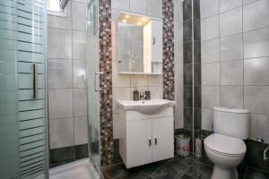 a bathroom with a toilet and a sink and a shower at Casa Del Sol in Skala Marion +15 photos