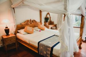 a bedroom with a bed with a canopy at Wayan Guest House in Ubud