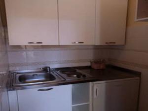 a kitchen with a sink and white cabinets at B&B Dei Rossi in Siena