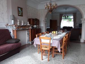 Gîte ferme du moulin في تورناي: غرفة طعام مع طاولة وكراسي طويلة