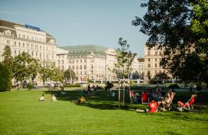 a group of people sitting on the grass in a park at Roosevelt Stadthaus in Vienna