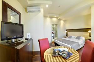 Pokój hotelowy z łóżkiem, telewizorem i stołem w obiekcie Hotel Vittoria w mieście Faenza