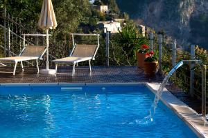 a pool with chairs and a pool table at H.H.Le Palme in Amalfi