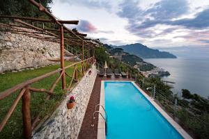 a pool with a balcony overlooking the ocean at H.H.Le Palme in Amalfi