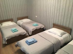a room with two beds with blue towels on them at Cherry in Stepantsminda