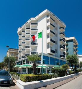 un hotel con una bandiera di fronte a un edificio di Hotel Margareth a Riccione