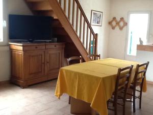 Un comedor con una mesa con televisión y una escalera. en Mas Tarquin, en Aigues-Mortes