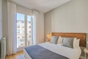 a bedroom with a bed and a large window at Apartaments Santa Clara – Baltack Homes in Girona