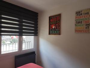 a bedroom with a window with black blinds and a sign at Barri Antic Hostel & Pub in Andorra la Vella