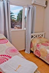 1 dormitorio con 2 camas y ventana en Complejo La Lucila en Puerto Madryn