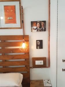 a bed sitting next to a wall next to a lamp at Barri Antic Hostel & Pub in Andorra la Vella