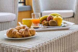 a table with two plates of pastries and fruit at Mare Del Sud in Torre San Giovanni Ugento