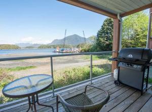 a patio with a grill and a table and chairs on a deck at Luxury Oceanfront Condo by OnlyBC 104 in Tofino