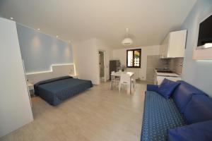 a living room with a blue couch and a kitchen at Casa Campanella Resort in Capoliveri