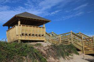 a wooden building on top of a sand hill at Oceanside Court by KEES Vacations in Nags Head