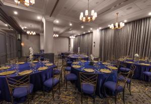 ワシントンにあるThe St Gregory Hotel Dupont Circle Georgetownの青いテーブルと椅子、シャンデリアが備わる客室です。