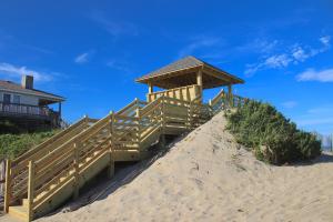 a building on top of a sandy beach at Oceanside Court by KEES Vacations in Nags Head