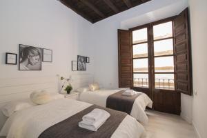 a room with two beds and a window at Zahira Suites in Granada