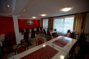 a dining room with red walls and tables and chairs at Guesthouse Mts in Međugorje