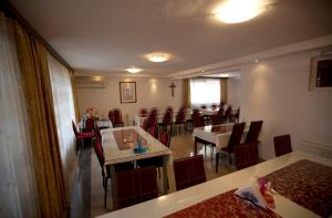 een eetkamer met tafels en rode stoelen bij Guesthouse Mts in Međugorje