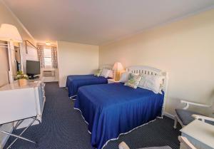 a hotel room with two beds and a television at Adams Ocean Front Resort in Dewey Beach
