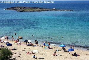 un grupo de personas en una playa con sombrillas en Salento Cecilia - solo settimane intere da sabato a sabato, en Torre San Giovanni