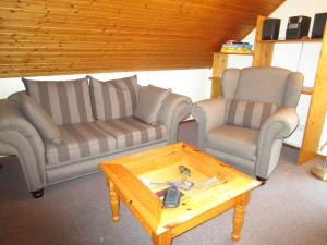 a living room with two couches and a coffee table at Ferienwohnungen am Wald in Lieser