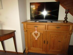einen Fernseher auf einer hölzernen Kommode in der Unterkunft Ferienwohnungen am Wald in Lieser
