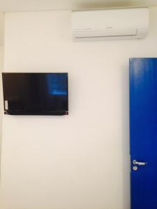 telewizor z płaskim ekranem wiszący na ścianie w obiekcie Pousada e Hostel São Paulo Comfort w São Paulo
