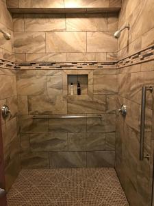 y baño con ducha y pared de piedra. en Golden Haven Hot Springs, en Calistoga