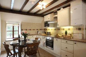 a kitchen with a table and a dining room at Vulcan Lodge Cottages in Rhayader