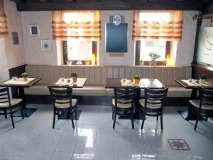 a dining room with tables and chairs in a restaurant at Restaurant & Hotel Exquisite in Bobenheim am Berg