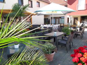 eine Terrasse mit Tischen, Stühlen und Blumen in der Unterkunft Restaurant & Hotel Exquisite in Bobenheim am Berg