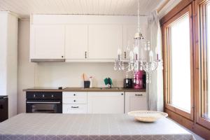 a kitchen with a table and a chandelier at Herrö stugor in Lemland