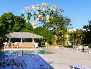 a swimming pool with a table and chairs and trees at One Love Cozy Studio Seawind On The Bay in Montego Bay