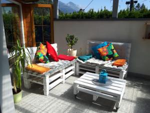 two benches with pillows and a table on a patio at Haus Elisabeth in Napplach