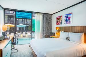 a hotel room with a bed and a desk and a window at The Verb Hotel in Boston