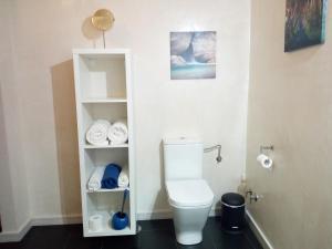 a bathroom with a toilet and some towels at El Patio De Catalina in Gaucín