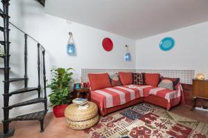 ローマにあるMoroni Trastevere Cozy Apartmentのリビングルーム(赤いソファ、階段付)