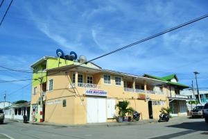 un edificio amarillo al costado de una calle en Hostel Stingray, en San Andrés