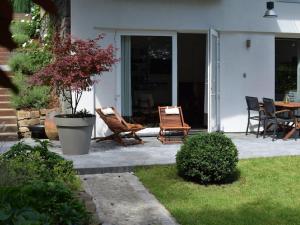 Gîte Au26 côté jardin-côté cour في لييج: فناء مع كرسيين وطاولة على منزل