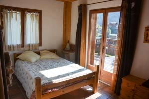 a bedroom with a bed and a sliding glass door at Chalet des Trappeurs Coeur Vanoise 15 persons in Champagny-en-Vanoise