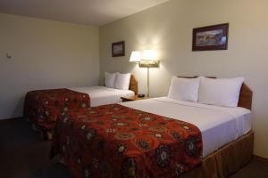 una camera d'albergo con due letti e una lampada di Armada Inn Motel a Unity