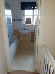 a bathroom with a sink and a mirror at Handy Dale House in Bathgate