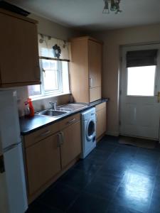 a kitchen with a sink and a washing machine at Handy Dale House in Bathgate