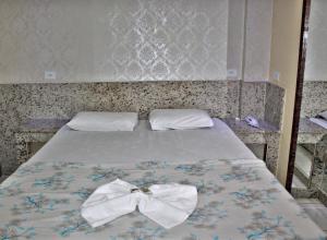 a bed with two bow ties on it at Hotel Farol da Barra in Manaus